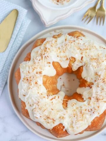 Coconut Bundt Cake topped with cream cheese frosting and toasted coconut.