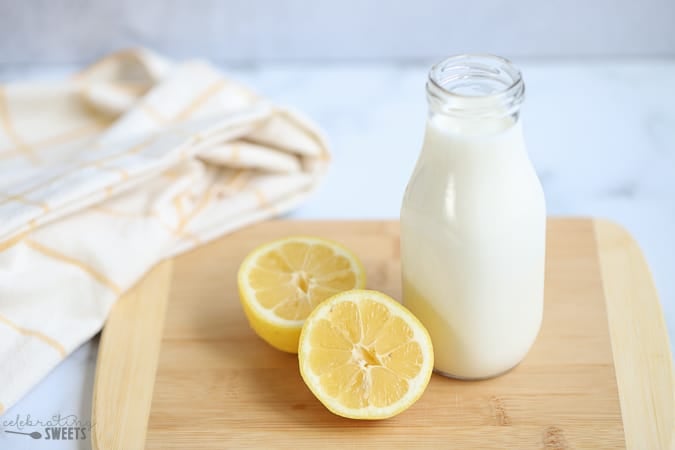 Milk in a glass jar and a halved lemon (how to make buttermilk)