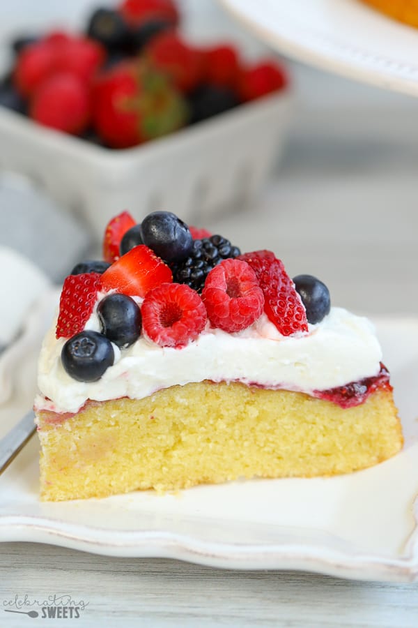 A slice of cake topped with whipped cream and mixed berries.