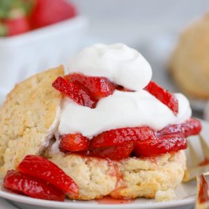 Strawberry Shortcake on a white plate with a gold fork.