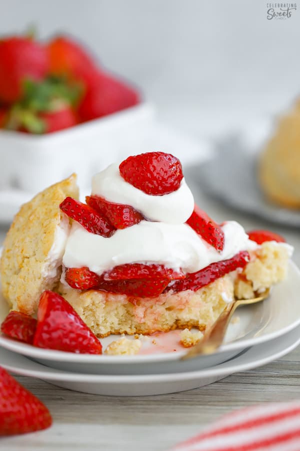 Strawberry Shortcake on a white plate with a gold fork. 