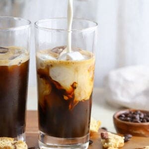 Milk being poured into iced coffee