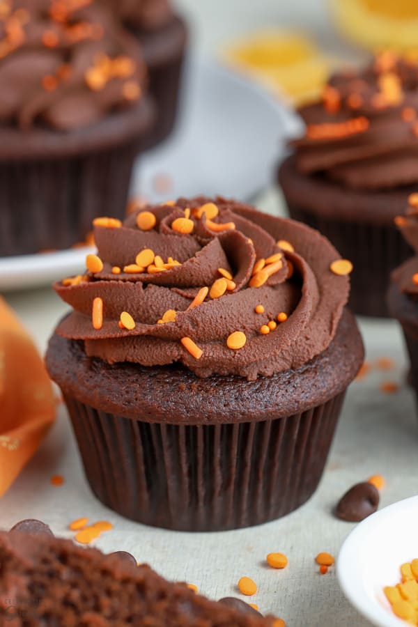 Chocolate orange cupcake topped with chocolate frosting and orange sprinkles. 
