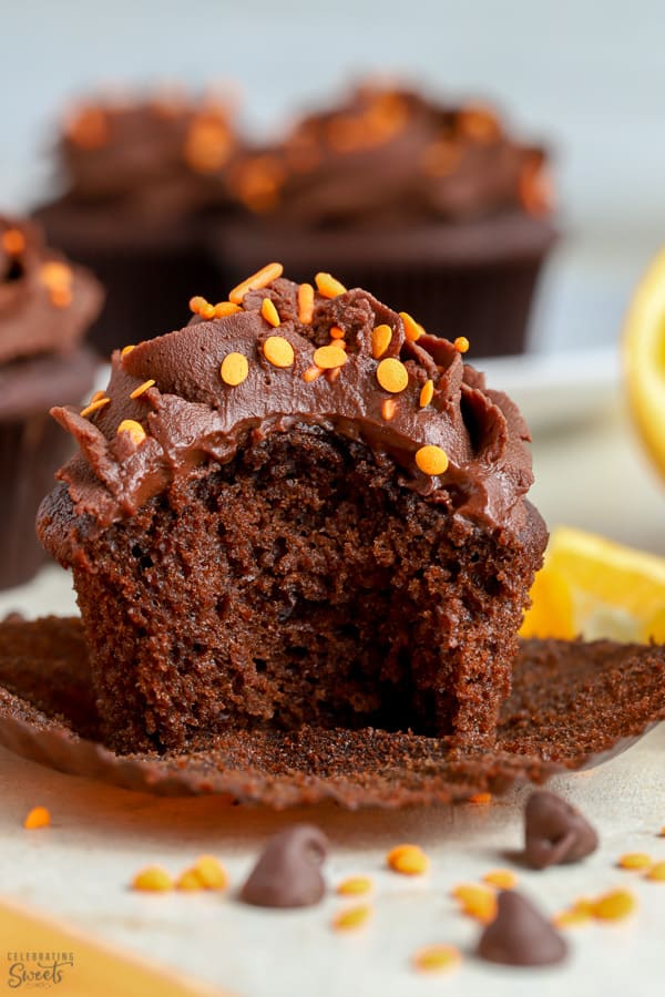 Chocolate cupcakes topped with chocolate frosting with a bite taken out of it.