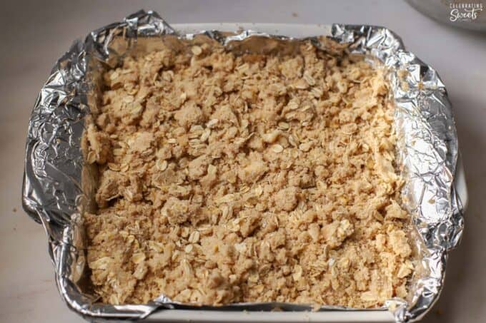 Crumb topped apple bars in a foil-lined baking pan.