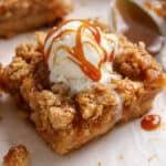 Apple crumb bar topped with vanilla ice cream and caramel sauce.