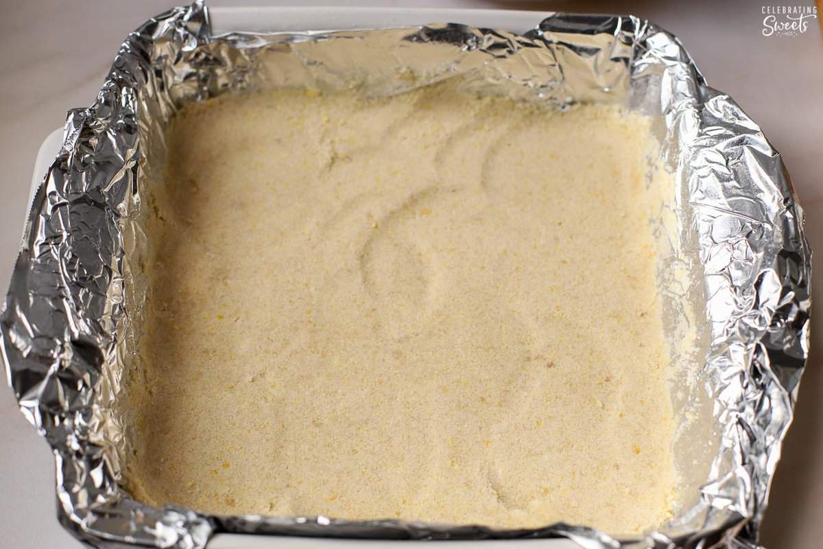 Shortbread crust pressed into a foil-lined pan.
