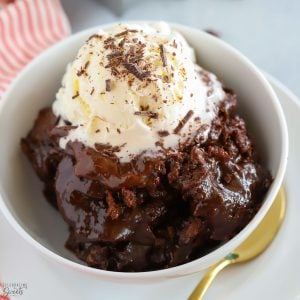 Chocolate Pudding Cake in a white bowl topped with a scoop of vanilla ice cream.