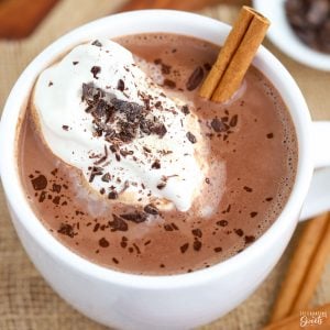 Mexican Hot Chocolate in a white mug topped with whipped cream and chocolate.