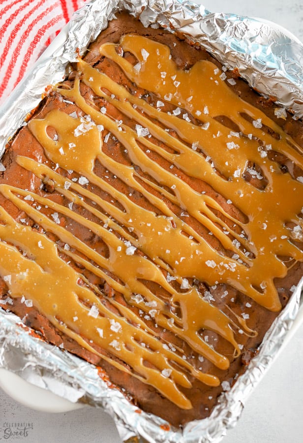 A square pan of brownies topped with caramel drizzle. 