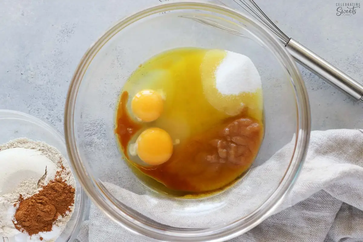 Sugar, eggs, applesauce in a glass bowl