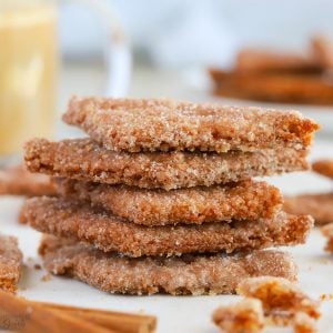 Stack of cinnamon cookies on parchment paper.