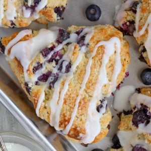 Closeup of a blueberry scone drizzled with icing.