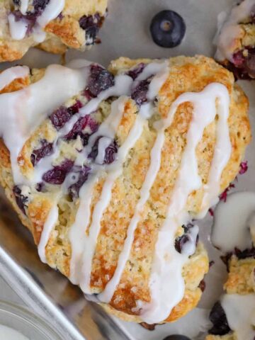 Closeup of a blueberry scone drizzled with icing.