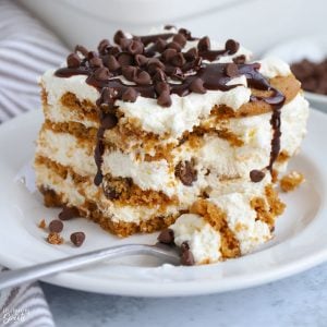 A piece of icebox cake topped with chocolate chips on a white plate.