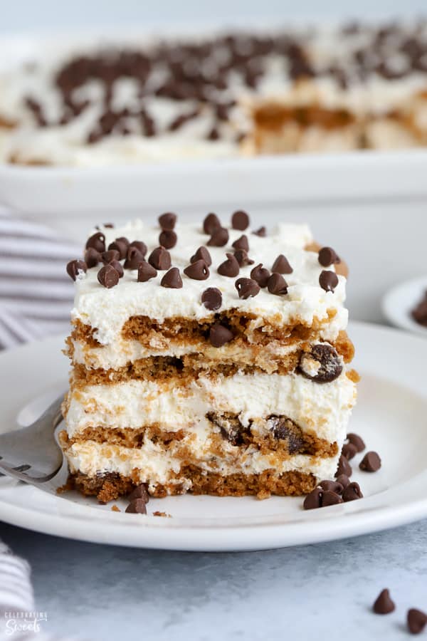 A slice of icebox cake topped with chocolate chips on a white plate.