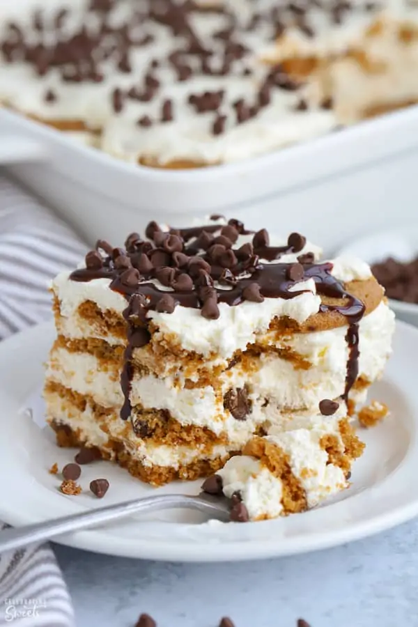 A slice of icebox cake topped with chocolate chips on a white plate.