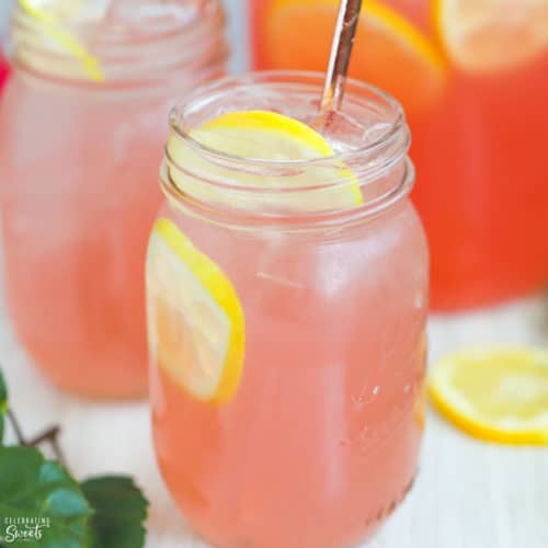 Mason jar filled with pink lemonade and lemon slices.