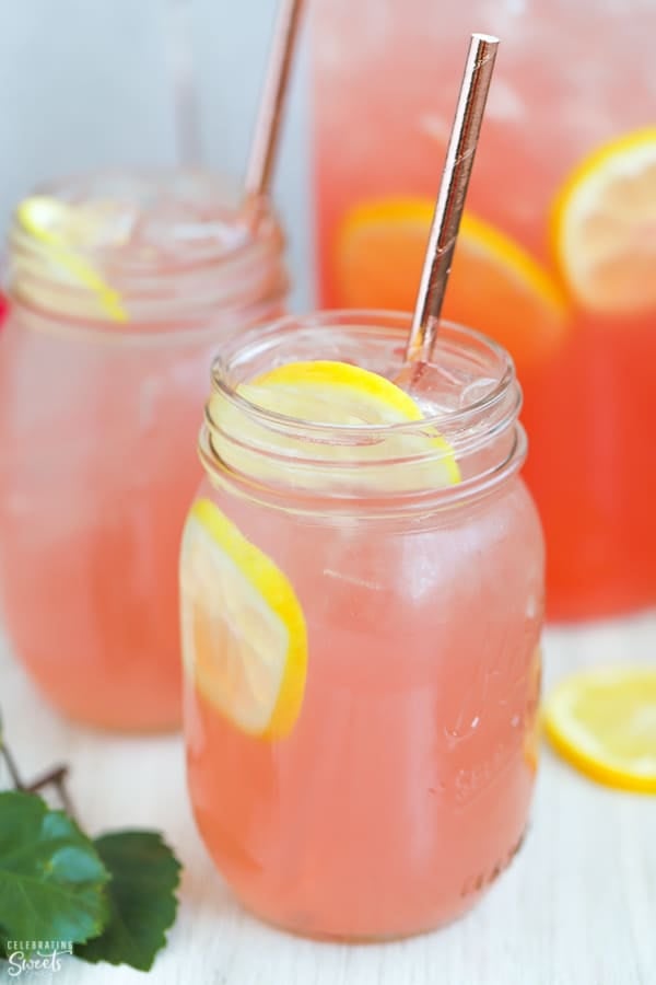 Mason jar filled with pink lemonade and lemon slices.