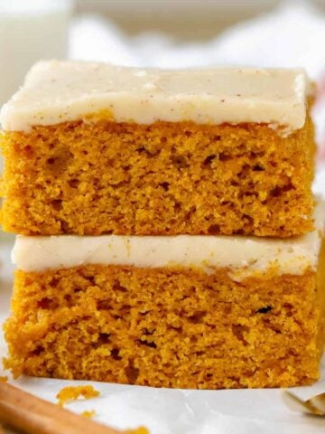 Stack of pumpkin bars on parchment paper.