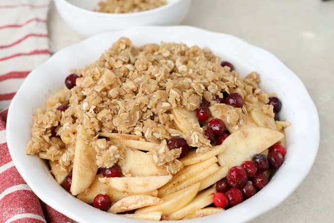 Apple cranberry crisp in a white baking dish.