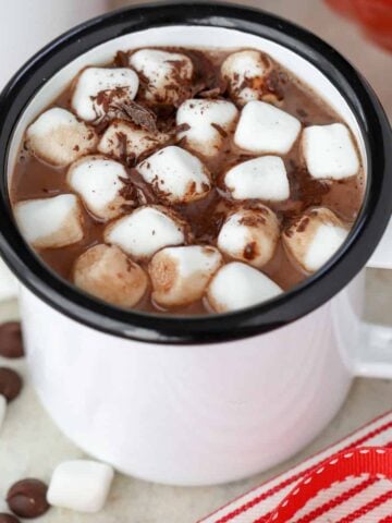 Hot chocolate in a white mug topped with marshmallows.