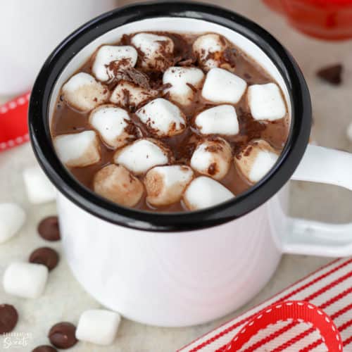 Hot chocolate in a white mug topped with marshmallows.