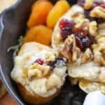 Baked brie cheese in a cast iron skillet with nuts