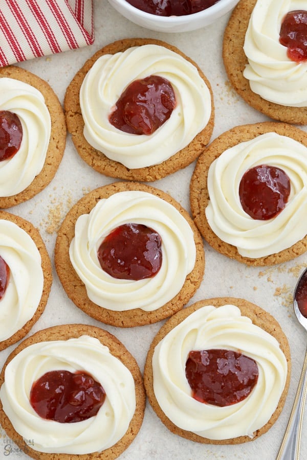 Cheesecake cookies with a swirl of frosting and jam in the center