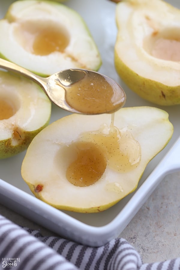Pears in a baking dish topped with honey.
