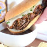 French Dip Sandwich dipped into a bowl of au jus