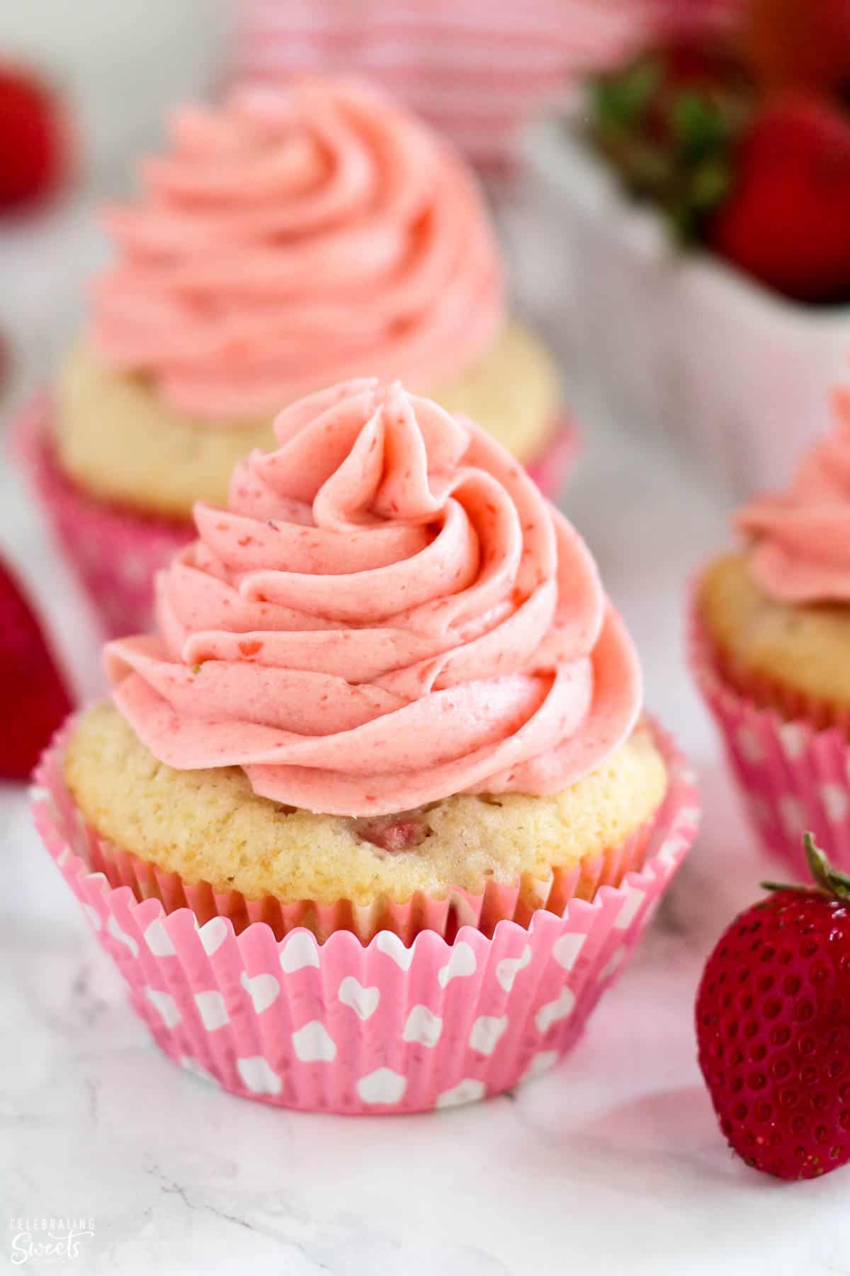 Closeup of strawberry cupcake topped with strawberry frosting