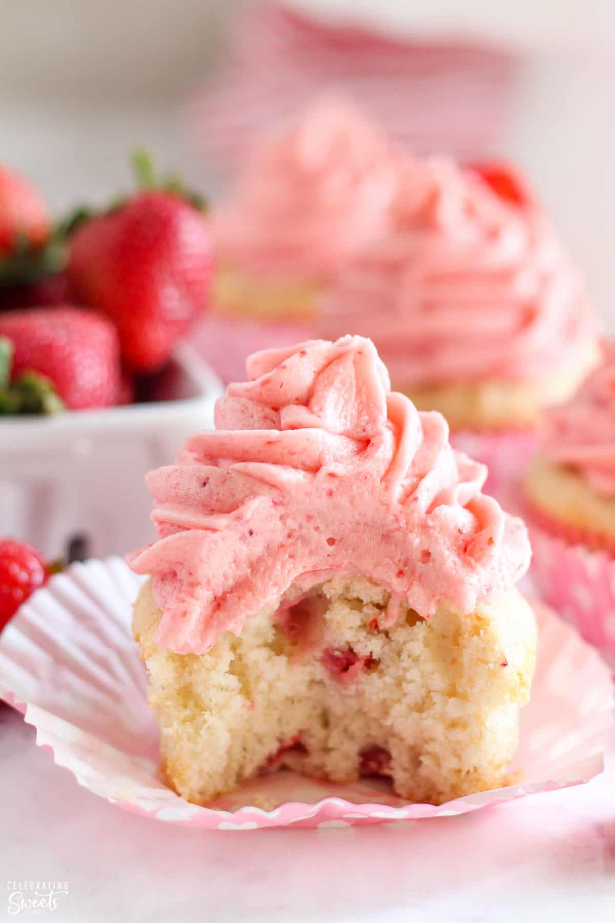 Strawberry cupcake with a bite taken out of it