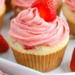 Strawberry cupcakes topped with pink icing and a fresh strawberry
