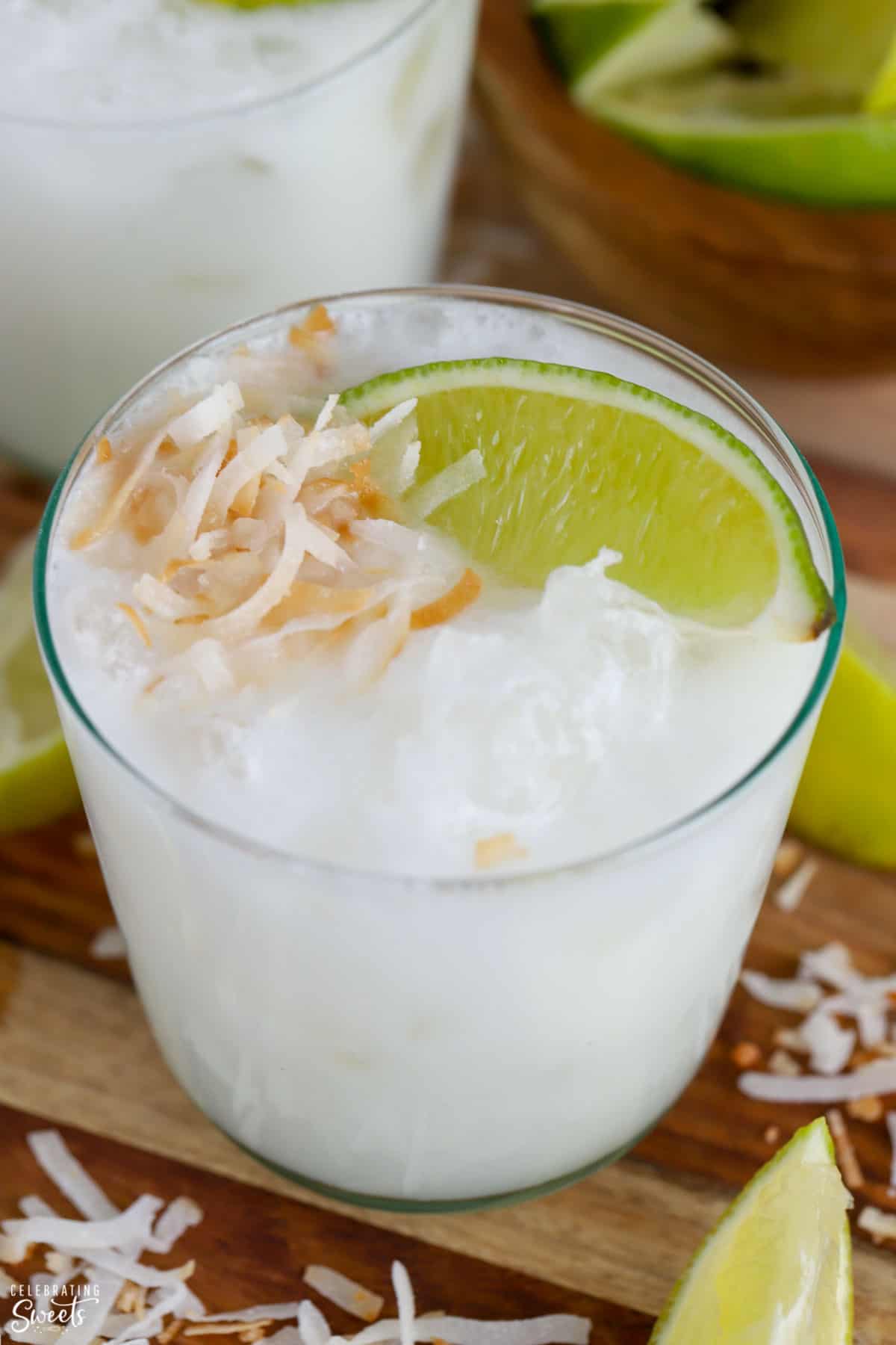 Close up of a coconut margarita topped with lime and toasted coconut.