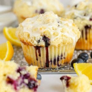 Closeup of a lemon blueberry muffin with crumb topping and white icing
