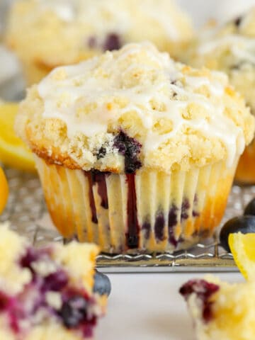 Closeup of a lemon blueberry muffin with crumb topping and white icing