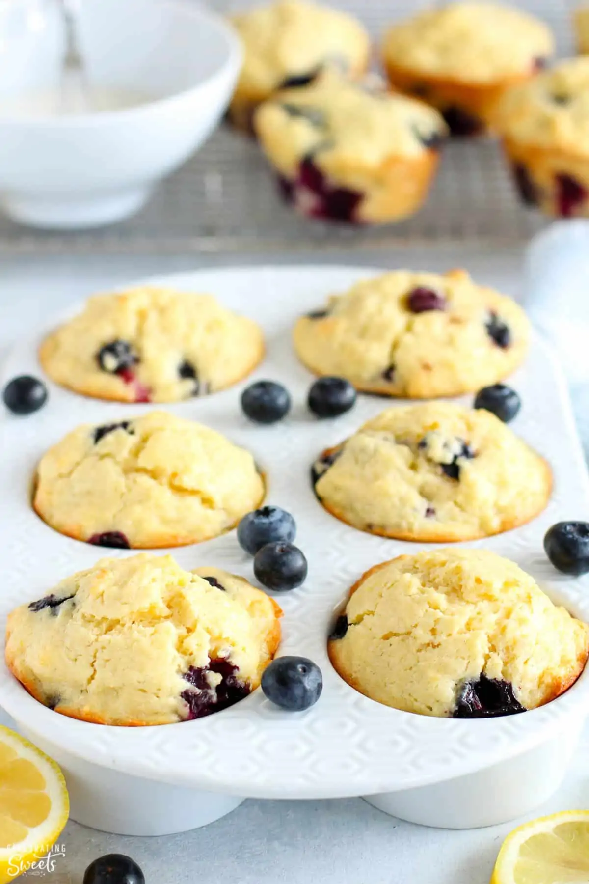Lemon Blueberry Muffins in a white muffin pan.