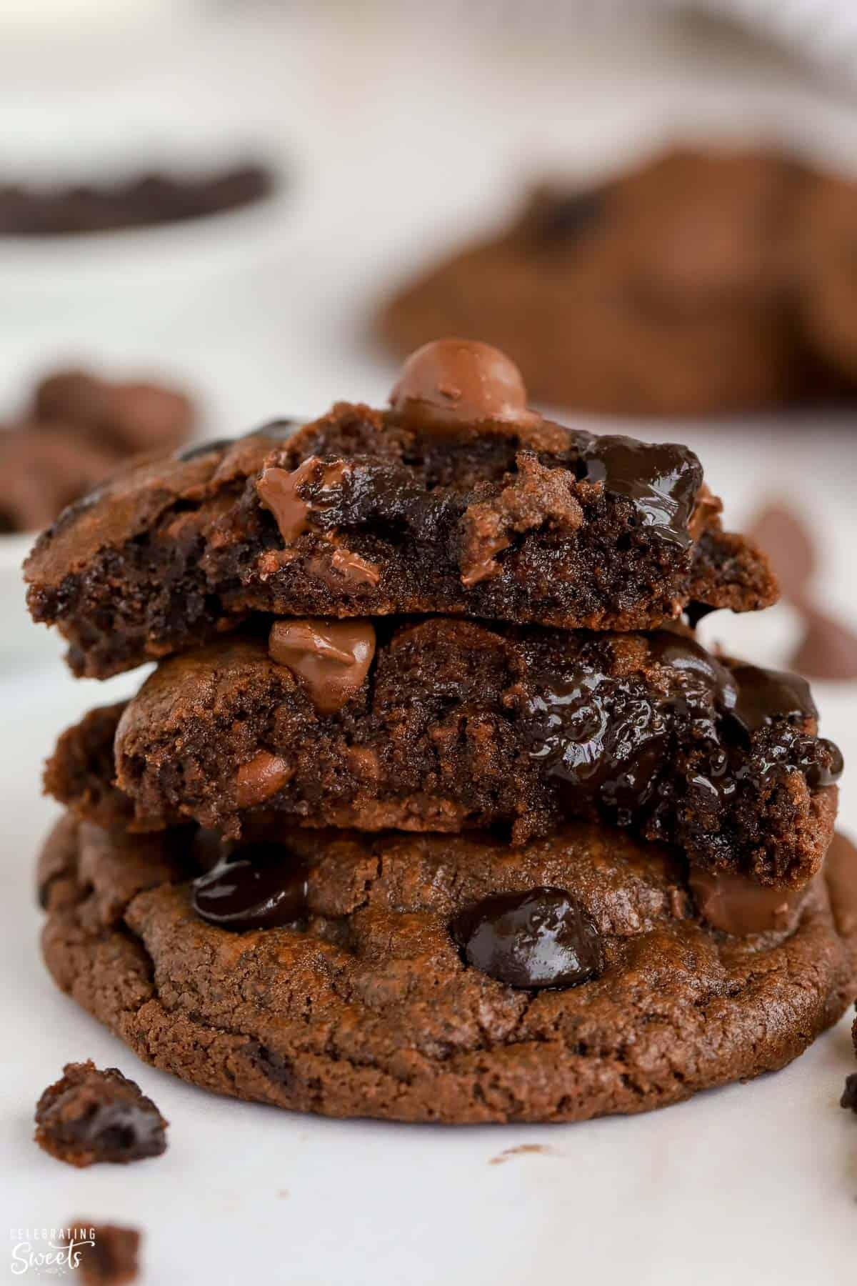 Stack of chocolate cookies broken in half with melted chocolate chips inside