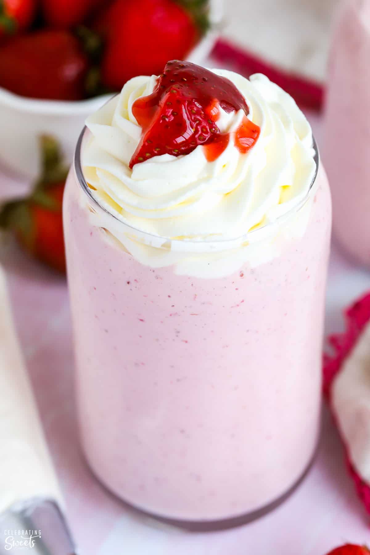 Closeup of Strawberry milkshake topped with whipped cream and strawberries