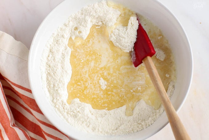 Flour, sugar, and melted butter in a white bowl.