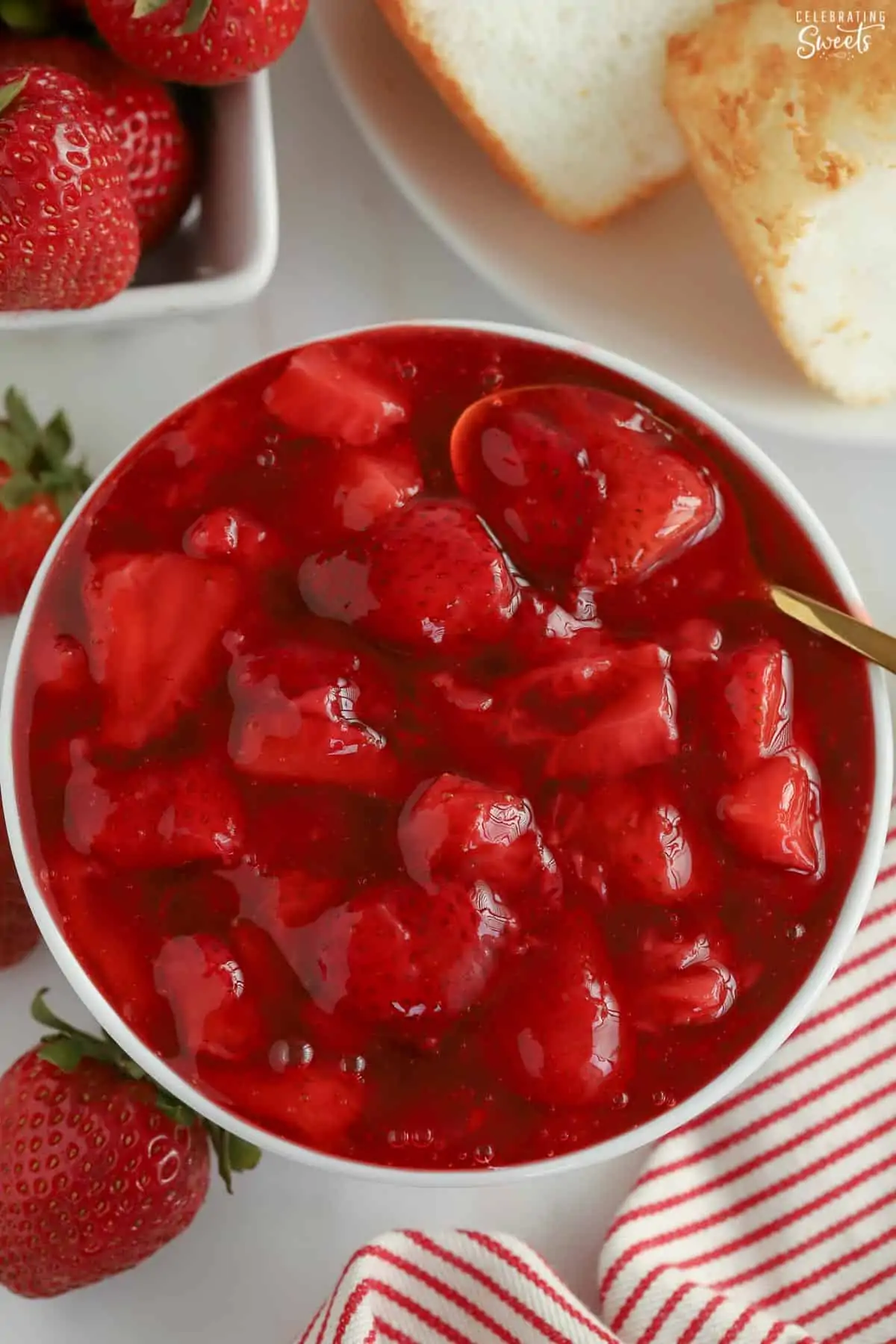 Strawberry Sauce in a white bowl with a gold spoon.
