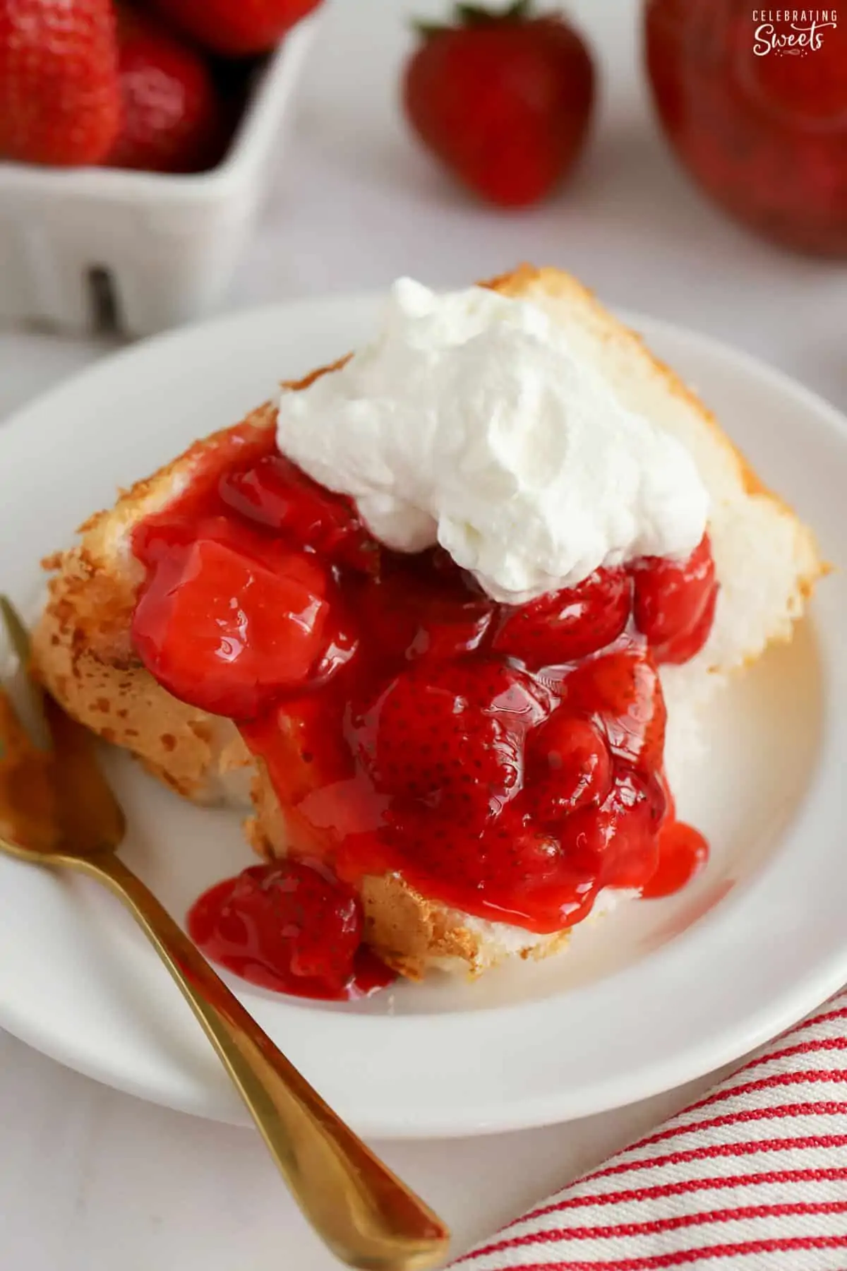 Strawberry sauce and whipped cream on a slice of angel food cake.