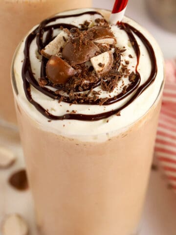 Closeup of chocolate malt topped with whipped cream and chocolate sauce.