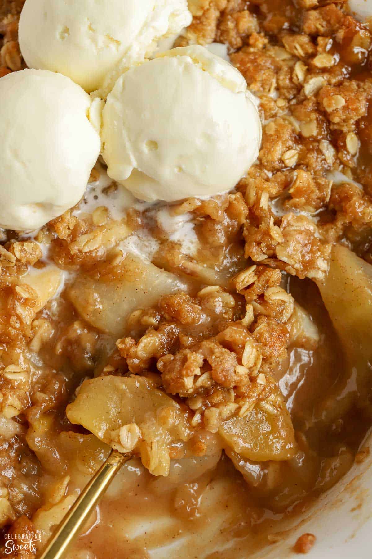 Closeup of Apple Pear Crisp topped with scoops of vanilla ice cream.