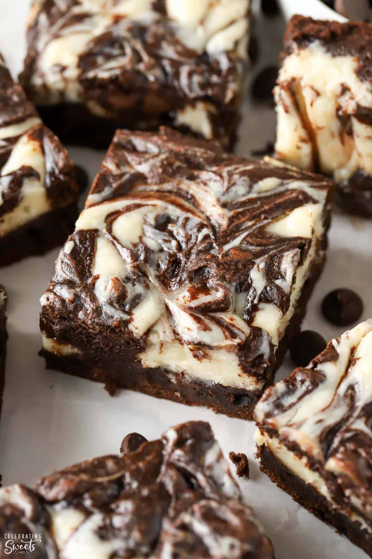 Overhead shot of cream cheese swirled brownies on a piece of parchment paper.