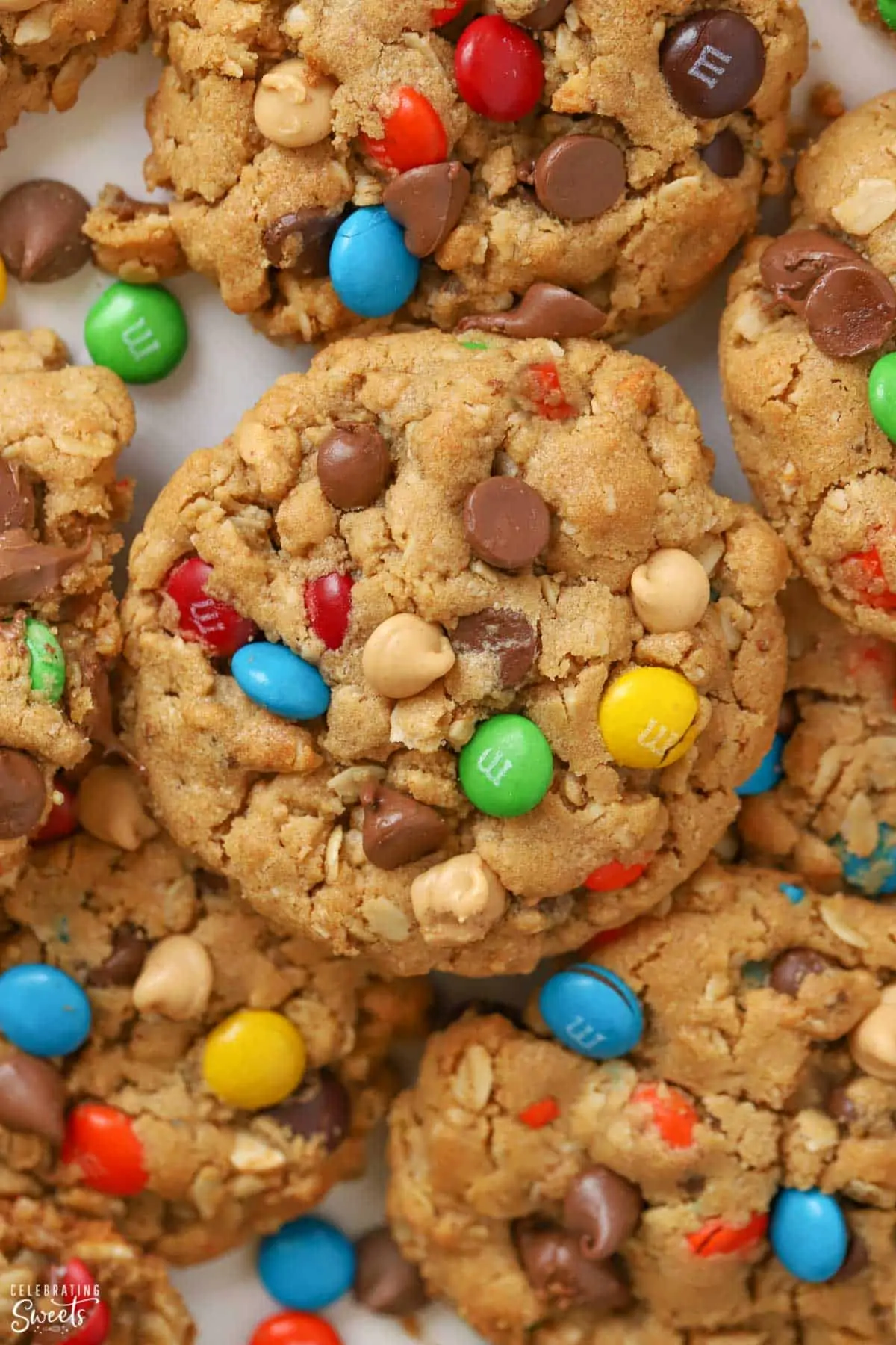 Closeup of Monster Cookies laying on parchment paper topped with M&M's and chocolate chips