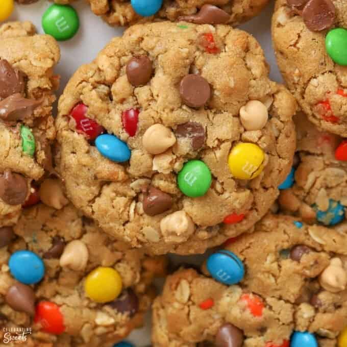 Closeup of Monster Cookies laying on parchment paper topped with M&M's and chocolate chips