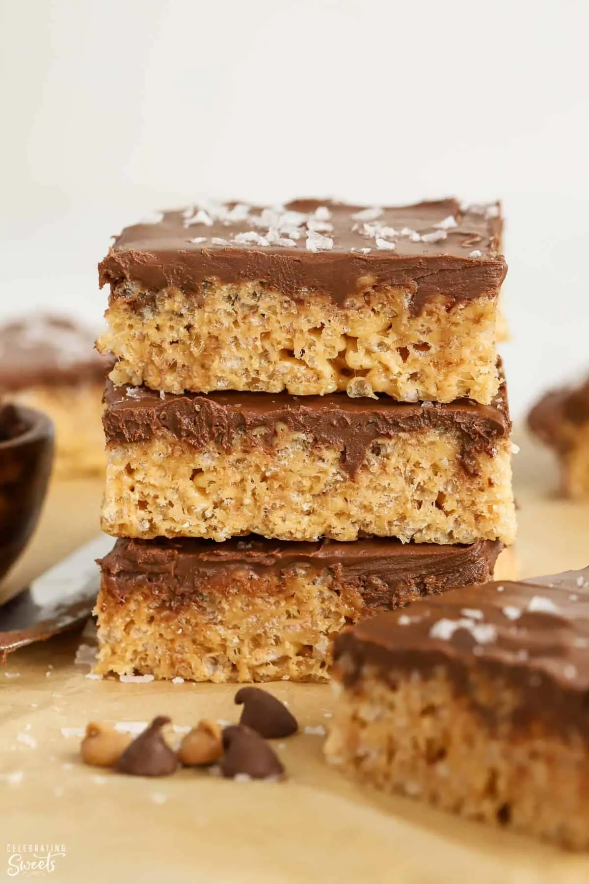 Stack of three peanut butter rice krispies treats topped with chocolate frosting.