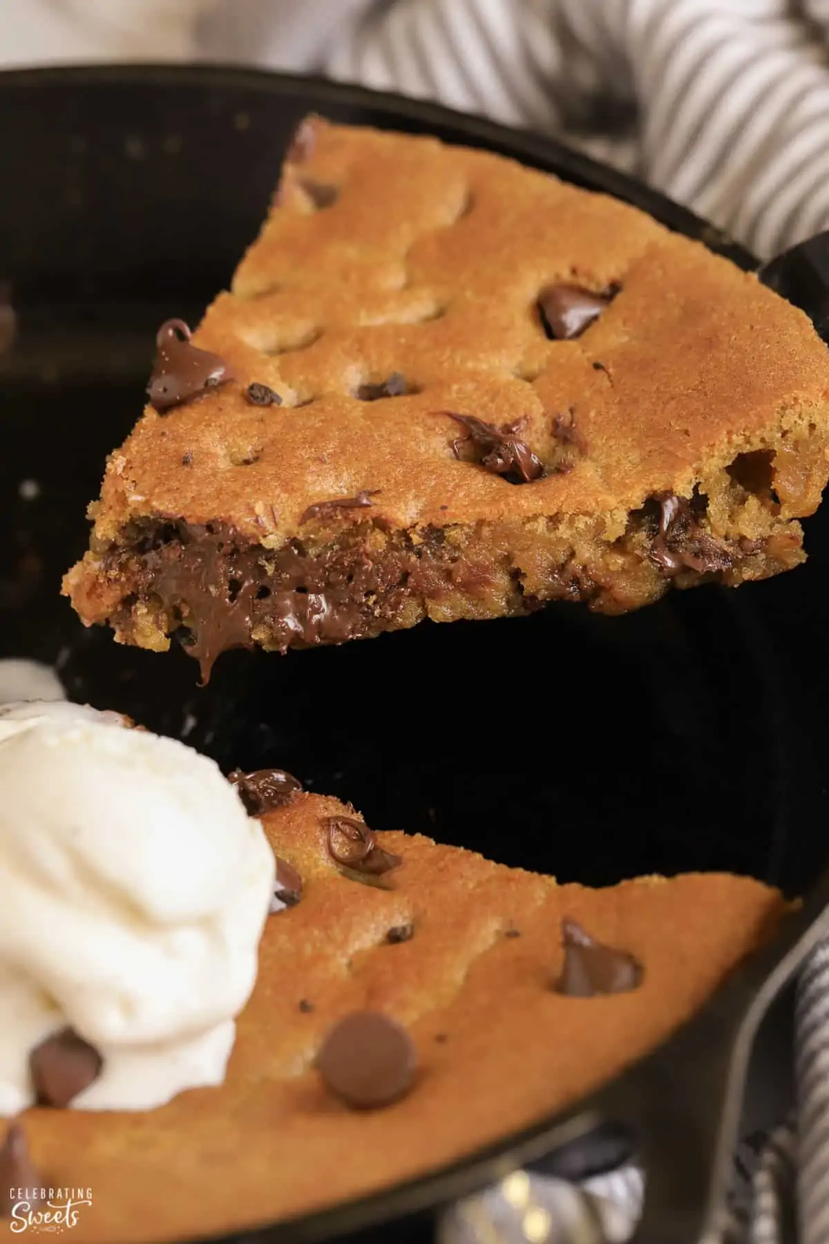 A slice of chocolate chip skillet cookie on a spatula.